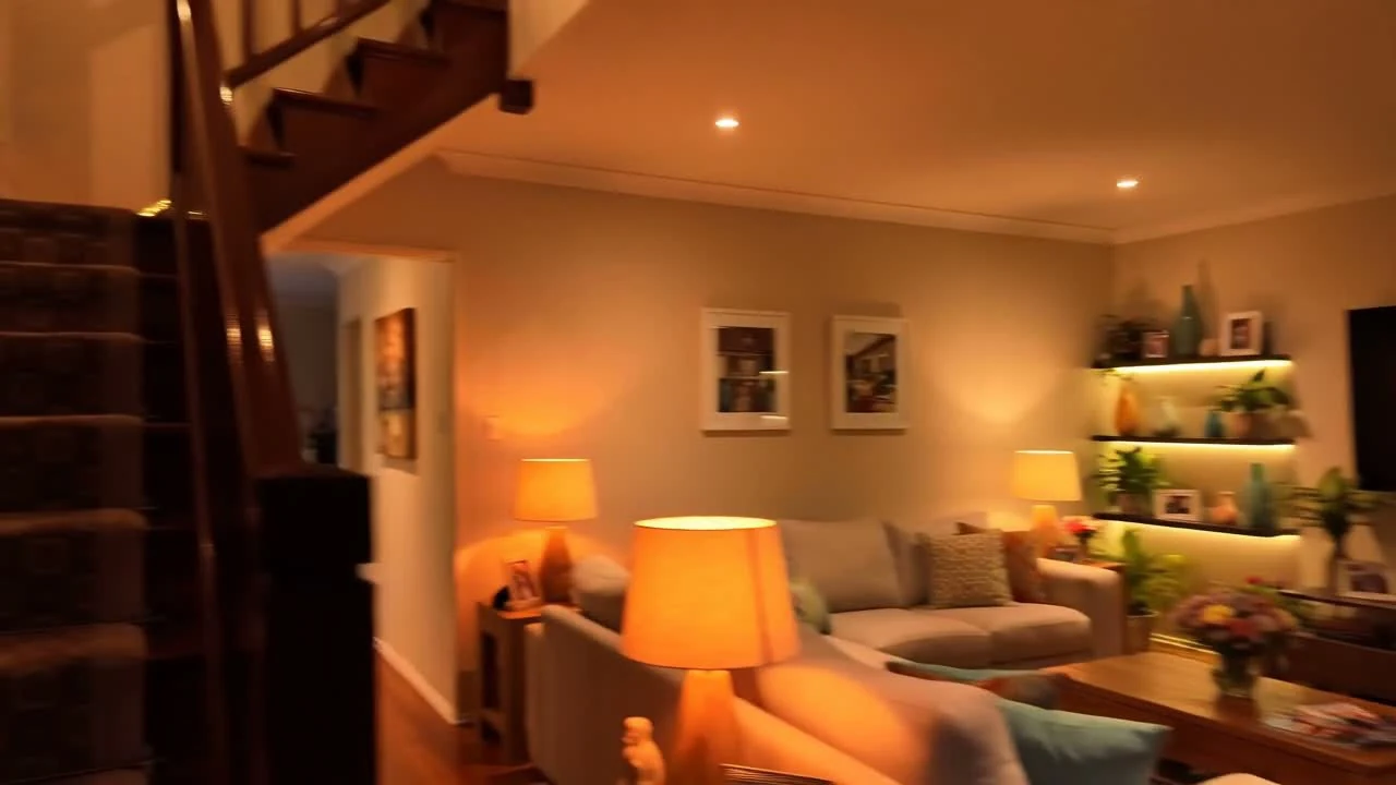 Sala de una villa australiana con iluminación cálida por capas al anochecer