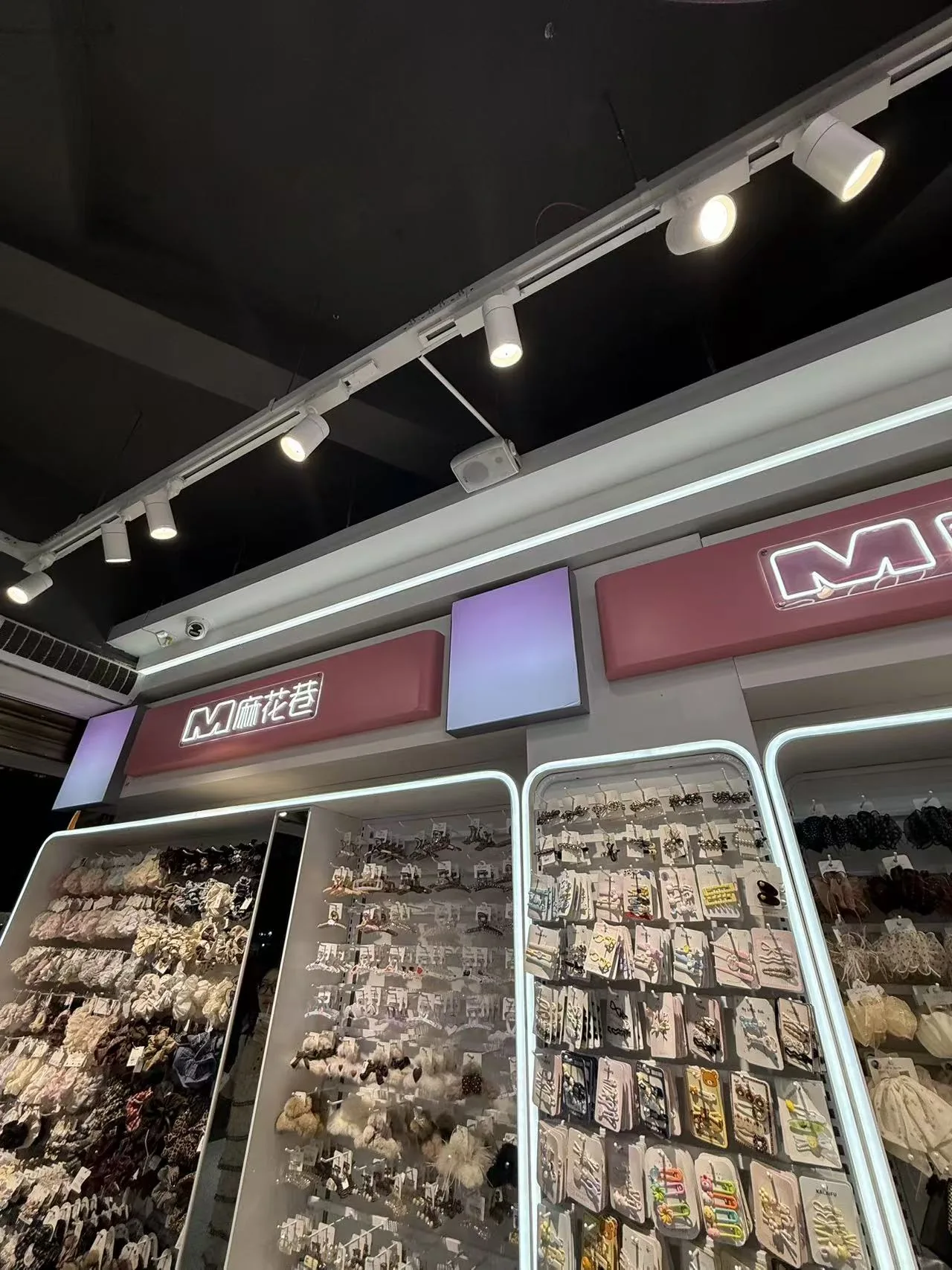 LED-Stromschienenstrahler beleuchten die Accessoire-Präsentationswand im Mahua Lane Geschäft in Changsha.