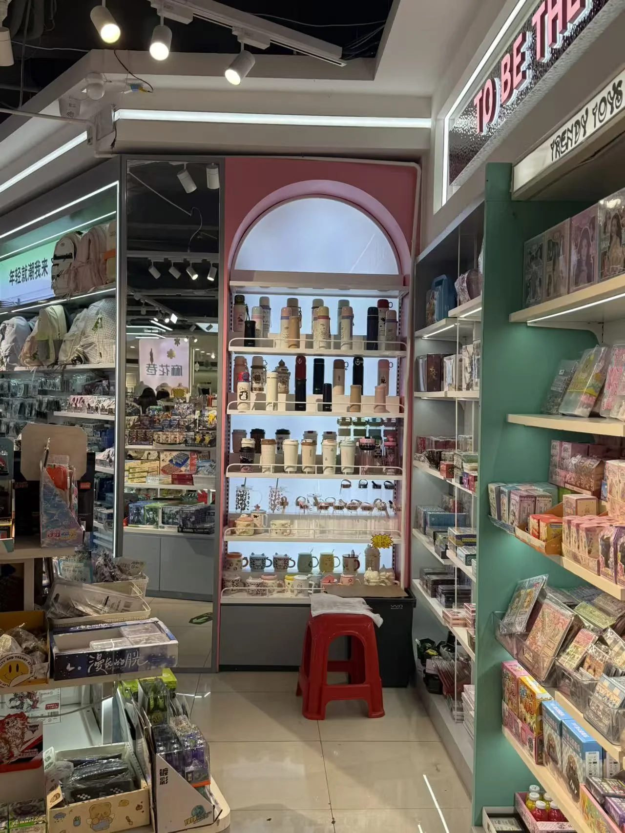 Beleuchtetes gewölbtes Präsentationsregal für Trinkgefäße und Lifestyle-Produkte im Mahua Lane Geschäft.